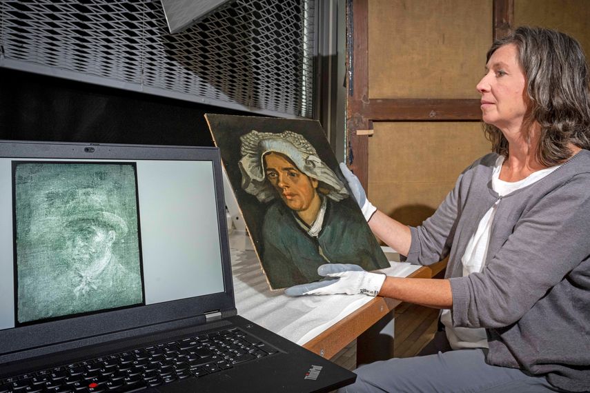 Una imagen distribuida por las Galerías Nacionales de Escocia el 14 de julio de 2022 muestra a la conservadora senior Lesley Stevenson viendo Cabeza de una mujer campesina junto a una imagen de rayos X de un autorretrato oculto del pintor holandés Vincent Van Gogh en Edimburgo.