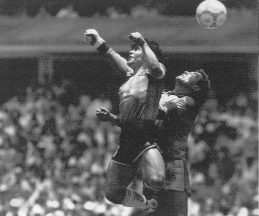En esta foto del 22 de junio de 1986, Diego Maradona supera al arquero inglés Peter Shilton y anota el llamado el gol de la Mano de Dios en el estadio Azteca de la Ciudad de México durante los cuartos de final de la Copa Mundial.&nbsp;