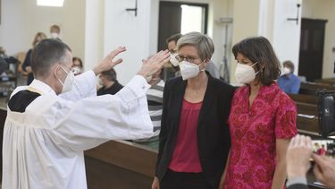 El vicario Wolfgang Rothe, a la izquierda, bendice a la pareja formada por Christine Walter, en el centro, y Almut Muenster, a la derecha, durante un servicio religioso católico en el que se bendijo a parejas homosexuales, en la iglesia de San Benedicto en Múnich, el domingo 9 de mayo de 2021.&nbsp;