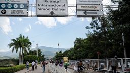 Los venezolanos cruzan el puente internacional Simón Bolívar sobre el río Táchira con sus compras mientras regresan a su país, desde Cúcuta, Colombia