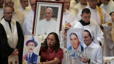 Miembros de la Arquidiócesis de Caracas muestran retratos de los santos venezolanos José Gregorio Hernández y Madre Carmen Rendiles durante una misa en honor al difunto Papa Francisco en Caracas el 26 de abril de 2025. 
