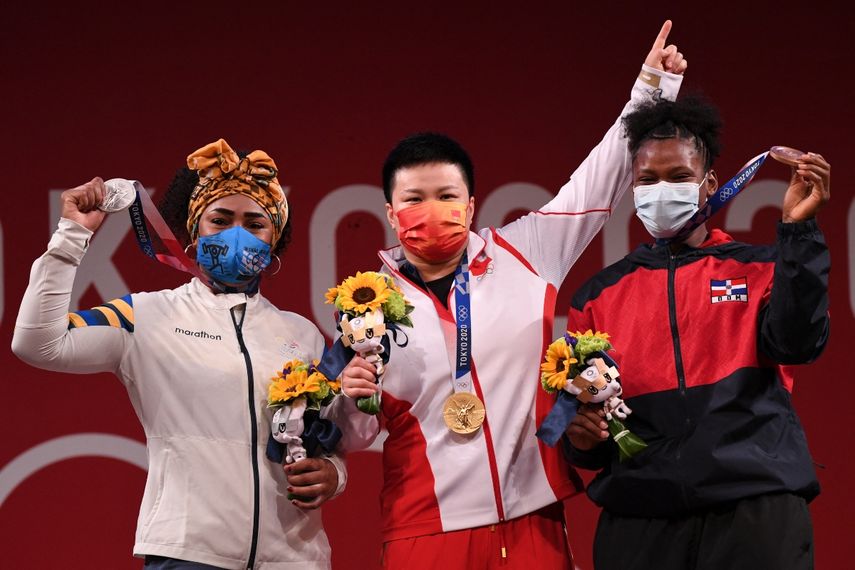 La medallista de oro de China Wang Zhouyu (C), la medallista de plata de Ecuador Tamara Yajaira Salazar Arce (L) y de República Dominicana Crismery Dominga Santana Peguero posan durante la ceremonia de entrega de medallas de la competencia femenina de halterofilia de 87 kg durante los Juegos Olímpicos de Tokio 2020