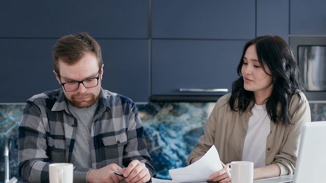 Una pareja prepara sus documentos para pagar sus impuestos anuales.