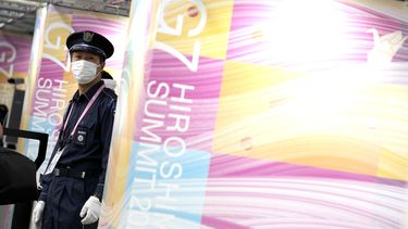 Un guardia de seguridad vigila mientras los periodistas hacen fila para entrar en el centro de medios de la cumbre del G7 el jueves de 18 de mayo de 2023 en Hiroshima, en el oeste de Japón. 