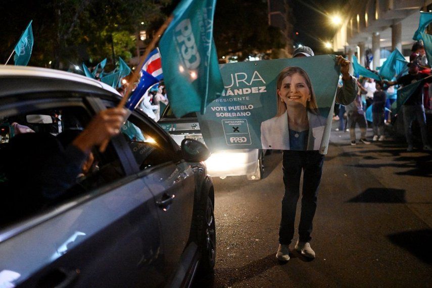 Partidarios de la candidata presidencial de Costa Rica del Partido Pueblo Soberano, Laura Fernández, ondean banderas mientras esperan los resultados de las elecciones presidenciales afuera del Hotel Aurola en San José el 1 de febrero de 2026.