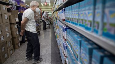 Un hombre observa los precios de la leche en un supermercado de Caracas.