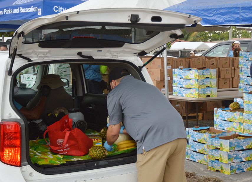 Los productos alimentarios son depositados en los maleteros de los vehículos.