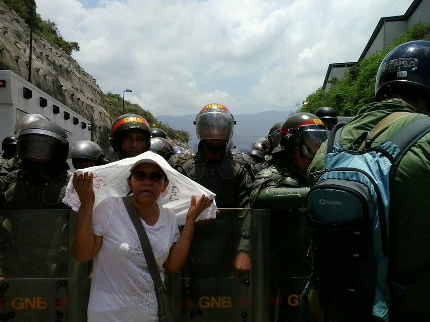 Una se&ntilde;ora se toma una foto con la Guardia Nacional. Desde 2014 la Guardia Nacional ha sido un organismo represor en Venezuela.&nbsp;