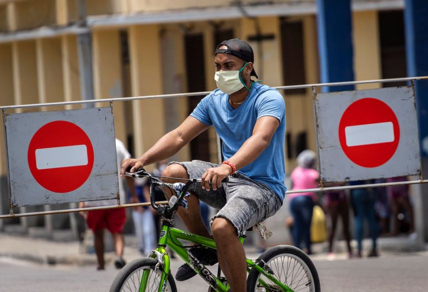 &nbsp; Un hombre con mascarilla viaja en bicicleta por una calle de La Habana.