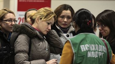 Una sicóloga conversa con familiares de las víctimas en el aeropuerto de Kazán el domingo. (AP)