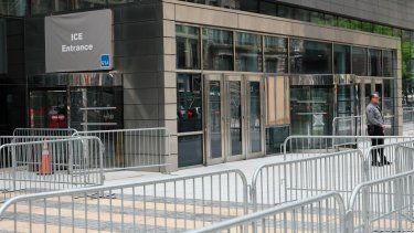 La foto muestra a un oficial de inmigración en la entrada del Edificio Federal Jacob K. Javitz en Nueva York, donde opera el tribunal de inmigración y las oficinas de ICE.