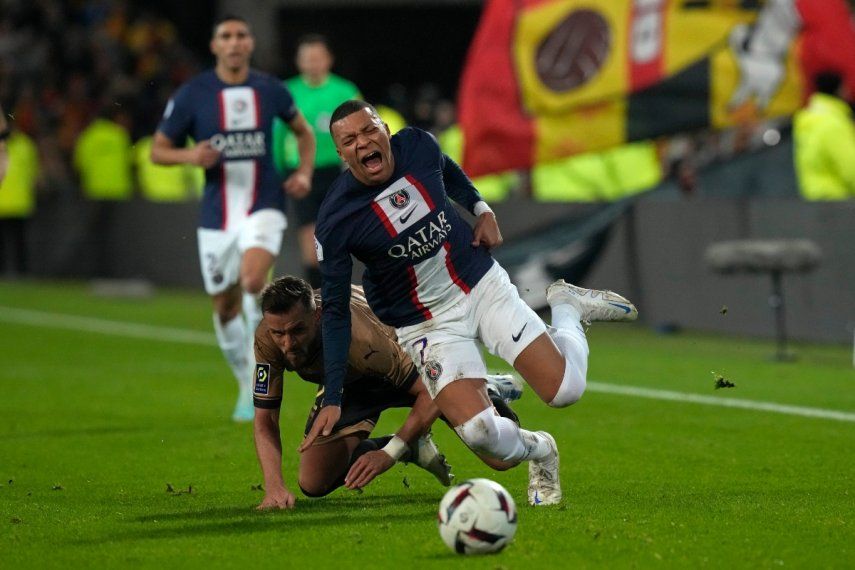 Kylian Mbappé, del PSG, recibe falta de Jonathan Gradit, del Lens, en el partido de la Liga Uno de fútbol de Francia en estadio Bollaert, en Lens, Francia, el domingo 1 de enero de 2023.&nbsp;