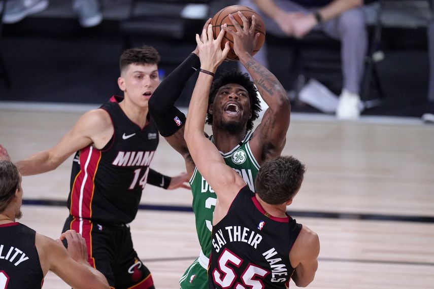 Kelly Olynyk (izquierda) y Duncan Robinson del Heat de Miami defienden mientras el base de los Celtics de Boston Marcus Smart trata de hacer un tiro durante la segunda mitad del juego de la NBA, el s&aacute;bado 19 de septiembre de 2020, en Lake Buena Vista, Florida