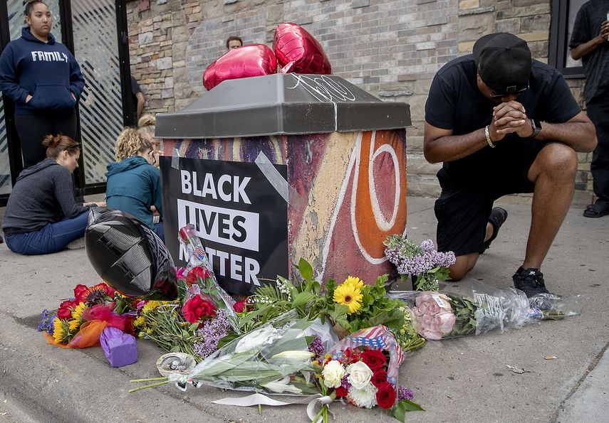Varias personas se re&uacute;nen alrededor de un memorial improvisado&nbsp;para honrar a George Floyd, el hombre afroestadounidense que muri&oacute; asfixiado durante una operaci&oacute;n de arresto policial en Minneapolis.