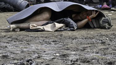 Un migrante venezolano descansa en el suelo en la aldea de Canaan Membrillo, el primer control fronterizo de la provincia de Darién en Panamá, el 12 de octubre de 2022. El viaje clandestino por el Tapón de Darién suele durar cinco o seis días a merced de todo tipo de males clima: serpientes, pantanos y narcotraficantes que utilizan estas rutas para llevar cocaína a Centroamérica.
