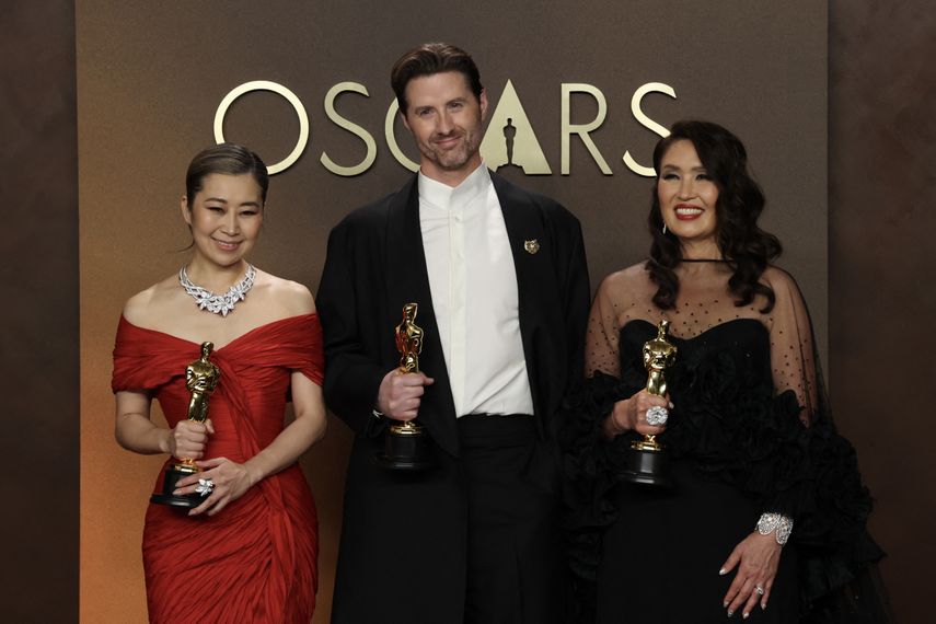 La artista y guionista surcoreana-canadiense Maggie Kang, el director de cine estadounidense Chris Appelhans y la productora de cine Michelle Wong posan en la sala de prensa con el Oscar a la Mejor Película de Animación por 