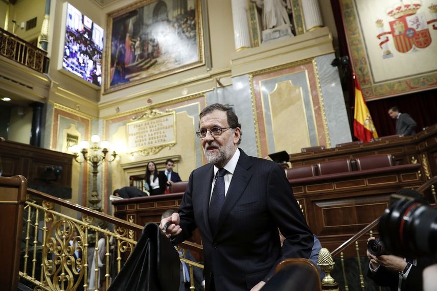 El presidente del Gobierno en funciones y candidato del PP, Mariano Rajoy, se dispone a ocupar su escaño al inicio de la sesión de la tarde de la segunda jornada del debate de investidura