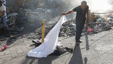 Una persona levanta la sábana que cubría un cadáver en el vecindario Petion Ville de Puerto Príncipe, Haití, el 18 de marzo de 2024. (Foto AP/Odelyn Joseph)