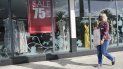 Una mujer pasa por delante de una tienda con un anuncio de descuentos frente a una vidriera en Pembroke Pines, Florida. Una mujer pasa por delante de una tienda con un anuncio de descuentos frente a una vidriera en Pembroke Pines, Florida.