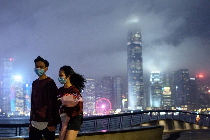 Una pareja camina por Hong Kong el 14 de febrero de 2020, y usa m&aacute;scaras ante el riesgo de contagio del coronavirus.