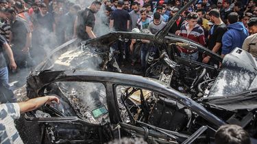 Palestinos inspeccionan el automóvil destruido del miembro de Hamas Hamed Al-Khodari después de ser golpeado por un ataque aéreo israelí en la ciudad de Gaza, el 5 de mayo de 2019.  