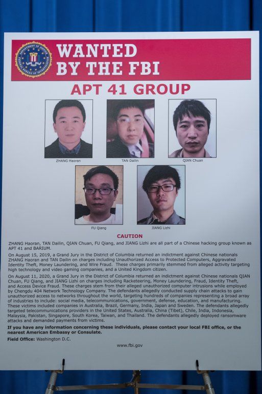 Un cartel con las fotografías y nombres de cinco hombres chinos buscados por el FBI
