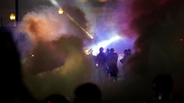 Policías con equipo antimotines alejan a manifestantes frente a un juzgado del condado de Kenosha, Wisconsin, que ha sido el lugar de los principales enfrentamientos entre manifestantes y autoridades, la noche del martes 25 de agosto de 2020. 