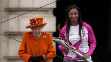 La atleta británica Kadeena Cox, quien ganó dos medallas de oro en los Juegos Paralímpicos de Río 2016, recibe el testigo de la reina Isabel II de Inglaterra para dar inicio a la carrera de relevo previa a los Juegos de la Commonwealth 2022, afuera del Palacio de Buckingham en Londres, el jueves 7 de octubre de 2021.
