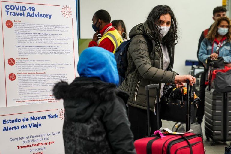 Varias personas portan mascarillas para evitar la propagación del COVID-19 en víspera de Acción de Gracias, mientras se preparan para abandonar la zona de entrega de equipaje en el Aeropuerto LaGuardia, el miércoles 25 de noviembre de 2020, en Nueva York. 