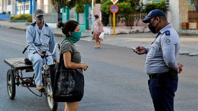 Un agente de la polic&iacute;a del r&eacute;gimen verfica a ciudadanos cubanos en las calles de La Habana, el 4 de abril de 2020.