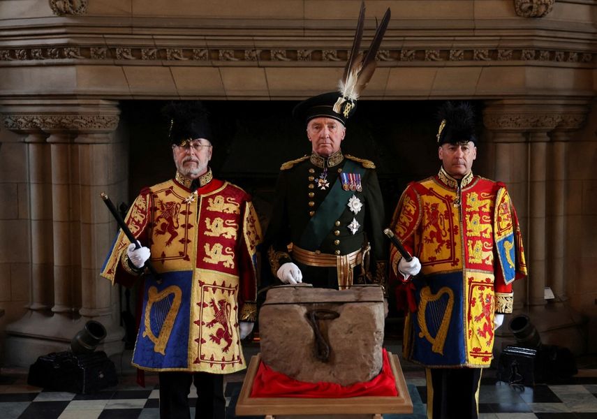 El duque de Buccleuch Richard Scott, flanqueado por dos Oficiales de Armas, se encuentra junto a la Piedra del Destino durante una ceremonia especial en el Castillo de Edimburgo el 27 de abril de 2023 antes de ser transportada a la Abadía de Westminster, Londres, para la Coronación del Rey Carlos III.