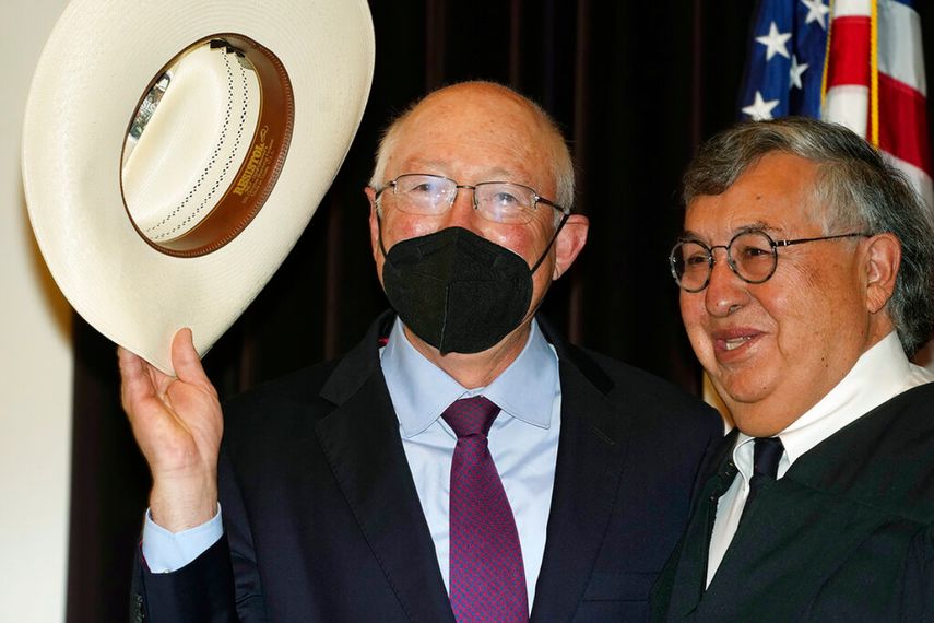 Ken Salazar (izquierda) saluda con el sombrero luego de prestar juramento como el embajador de Estados Unidos en México, el jueves 26 de agosto de 2021, en Denver.