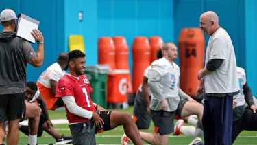 El coordinador ofensivo de los Dolphins de Miami, George Godsey, dialoga con el quarterback Tua Tagovailoa (1) durante una sesión de entrenamiento del equipo