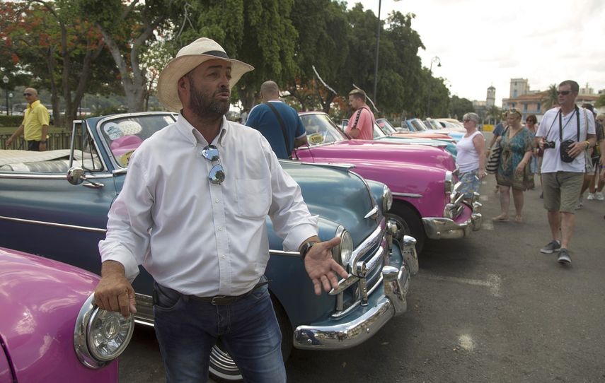 Fotografía de archivo fechada el 5 de junio de 2019 de Yosbell Figueroa, un trabajador privado que maneja un auto clásico para mantener a su familia en La Habana.