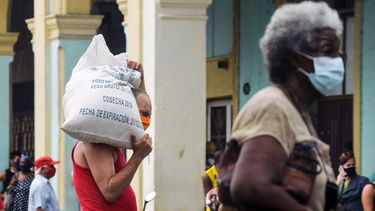 Personas con mascarillas hacen cola frente a una tienda en La Habana, Cuba.
