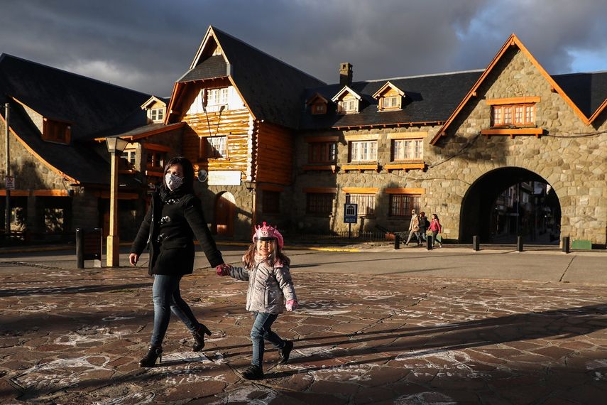 Las personas con máscaras faciales caminan al lado del Centro Cívico de Bariloche, durante el cierre impuesto por el gobierno contra la propagación del nuevo coronavirus, COVID-19, en Bariloche, Río Negro, Argentina, el 24 de junio de 2020.  