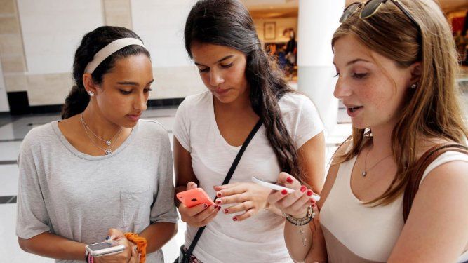 Isabella Cimato, de 17 años, izquierda, Arianna Schaden, de 14, y Sofia Harrison, de 15, revisan sus teléfonos en el centro comercial Roosevelt Field en Garden City, Nueva York.