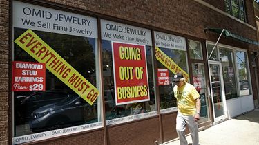 Un hombre camina frente a un negocio cerrado tras el impacto de la pandemia.