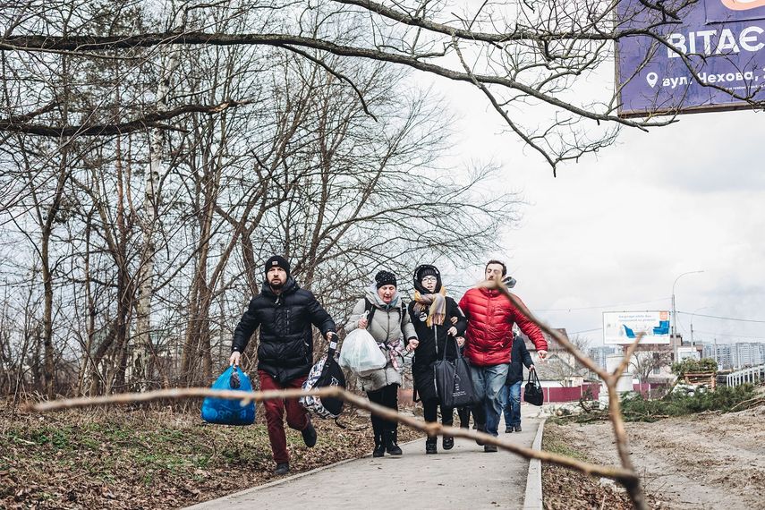 Una familia corre ante el bombardeo, a 6 de marzo de 2022, en Irpin (Ucrania). El alto el fuego que estaba previsto este domingo en la localidad ucraniana de Irpin para establecer un corredor humanitario ha fracasado.&nbsp;&nbsp;