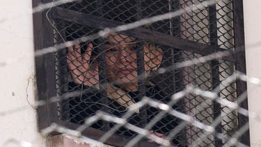La expresidenta interina de Bolivia, Jeanine Áñez, saluda desde una ventana de la cárcel de mujeres de Miraflores.
