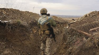 Un soldado ucraniano cargando un gato camina en una trinchera en la línea de separación de los rebeldes separatistas que apoya Rusia cerca de Debaltsevo, región de Donetsk, Ucrania, el viernes 3 de diciembre de 2021.&nbsp;