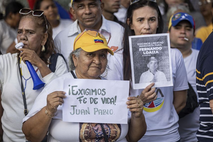 Personas sostienen carteles durante una manifestación por la libertad de los presos políticos y del opositor Juan Pablo Guanipa, este lunes en Maracaibo (Venezuela).&nbsp;