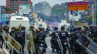 Miembros de la Guardia Nacional dispersan con gases lacrimógenos una movilización opositora en el este de Caracas.