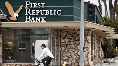Un joven en bicicleta pasa frente a una sucursal del First Republic Bank.