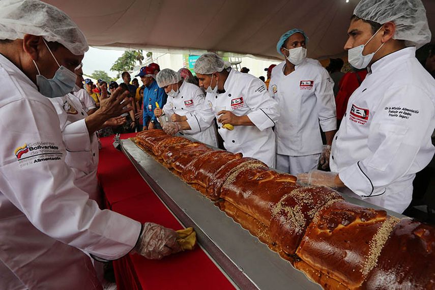 Varios cocineros dan los toques finales al mayor pan de jamón del mundo, en Caracas, Venezuela, el sábado 15 de noviembre de 2014. (AP)