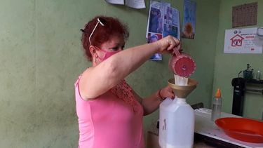 Venta de leche racionada a granel en una bodega en Matanzas. 