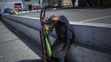 Un hombre se duerme sobre el carrito que usa para transportar mercader&iacute;as en un supermercado de Lima el 19 de marzo del 2020. El individuo no puede quedarse en su casa en plena pandemia del coronavirus porque si no trabaja no come.