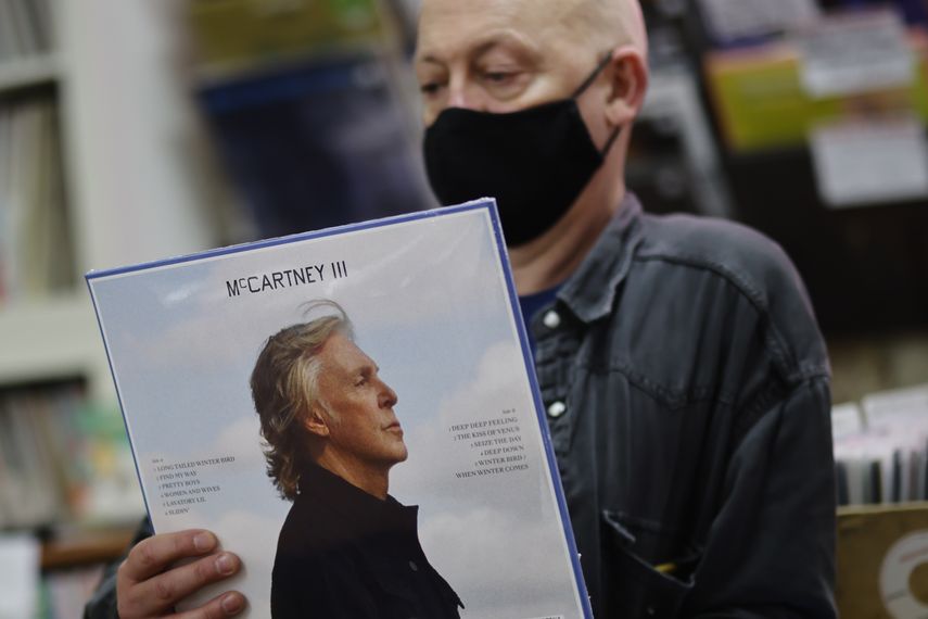 Karl Shale posa con una copia del nuevo álbum McCartney III del músico británico Paul McCartney en la tienda de discos Sounds of Universe en Londres el 18 de diciembre de 2020.&nbsp;