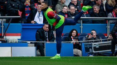 Kylian Mbappé del París Saint-Germain calienta durante el partido contra Reims en la liga francesa, el domingo 10 de marzo de 2024. 