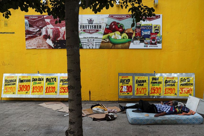 Un indigente duerme en un colchón en una acera cerca de una tienda de abarrotes en Santiago, Chile, el miércoles 2 de diciembre de 2020. Aunque América Latina y el Caribe disponen de alimentos para satisfacer a sus más de 600 millones de habitantes, el año pasado 191 millones de personas tuvieron una alimentación insuficiente y de ellas 47,7 millones pasaron hambre, según un informe de las Naciones Unidas divulgado el miércoles.